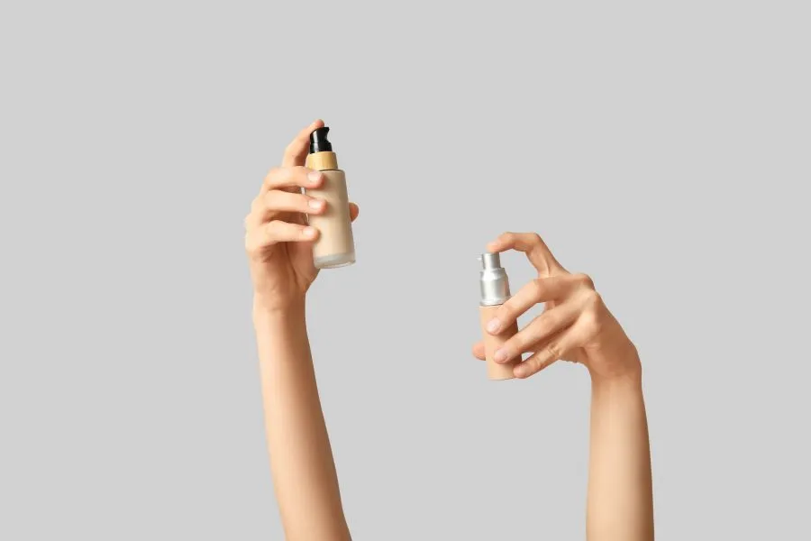 Hands holding two makeup products.